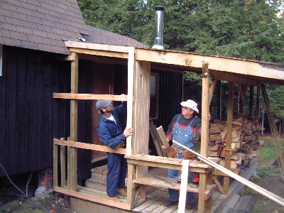 Robert Kivi ja Toomas Marley ehitavad rõdule puukuuri.  Puukuuri seinast saab ka tuulevari ja lumetuisuvari Lembitu külas asuvale Peretarele. - pics/2004/arg6.jpg