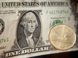 A Canadian dollar coin falls past a United States dollar in Ottawa, on Wednesday Oct.22, 2008. (Adrian Wyld / THE CANADIAN PRESS) - pics/2008/10/21392_1.jpg