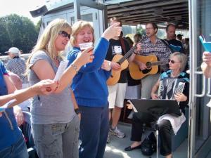  On the way to the folk festival, accompanied by the tunes of former Toronto resident, now Vancouverite Aarne Tork (face hidden) and Montréaler, then Torontonian, now Portlander Erik Teose on guitar with  Liina Teose on accordion. Photo: Arved Plaks  - pics/2009/09/25342_6_t.jpg