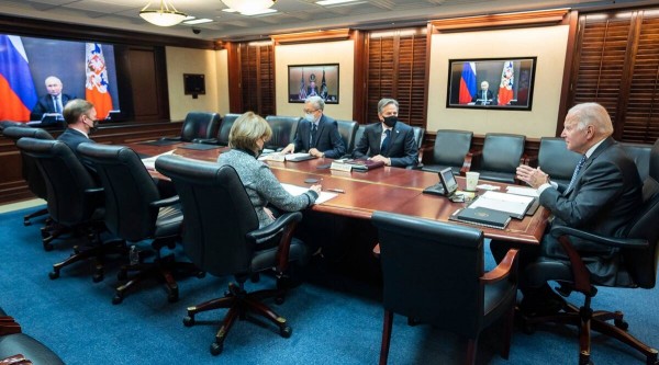 A photo provided by the White House shows US President Joe Biden, right, at the White House in Washington, as President Vladimir Putin of Russia appears on video monitors during their virtual meeting on Tuesday, Dec. 7, 2021. Secretary of State Antony Blinken, second from right, and other officials also attended. (White House via The New York Times) - pics/2021/12/58805_001_t.jpg