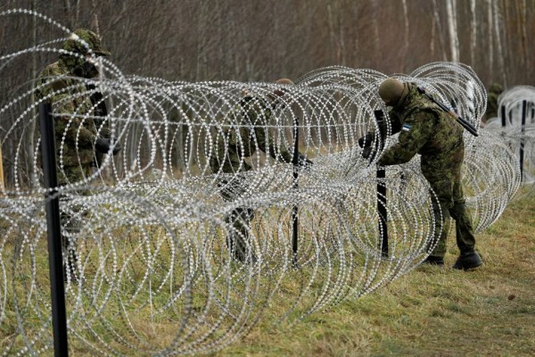 Estonian army reservists build a temporary razor wire fence on a border with Russia during a snap military exercise Okas 2021 near Meremae, Estonia November 20, 2021. REUTERS/Ints Kalnins - pics/2022/01/58896_001_t.jpg