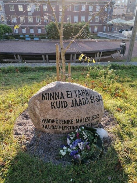 Nüüd saab minna mälestama 1944. a. suurpõgenemise üle elanud või selle käigus hukkunud inimesi Tallinna vanalinnas Rootsi-Mihkli kiriku ja Niguliste kiriku vahelisel platsil Rüütli tänaval. Kivil on kirjas: Minna ei taha kuid jääda ei saa. Paadipõgenike mälestuseks. Selle all on rootsi keeles till båtflyktingars minne ning ees esimene mälestuskimp ÜEKN lindiga. Kivi paigaldasid Eestirootslaste Kultuuriomavalitsus koos Tallinna Rootsi-Mihkli kiriku kogudusega. Mälestuskivi on suunaga läände; selle tagant, Harju tänava majade kohalt paistib sügisene hommikupäike. Kivi taga on suviti pargiala, millest talvel saab uisuväli. Foto: Riina Kindlam - pics/2022/09/59614_002_t.jpg