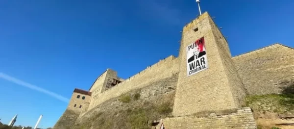 Poster of Putin covered in blood on the wall of a castle in Narva. PHOTO: ERR - pics/2023/05/60206_001.webp